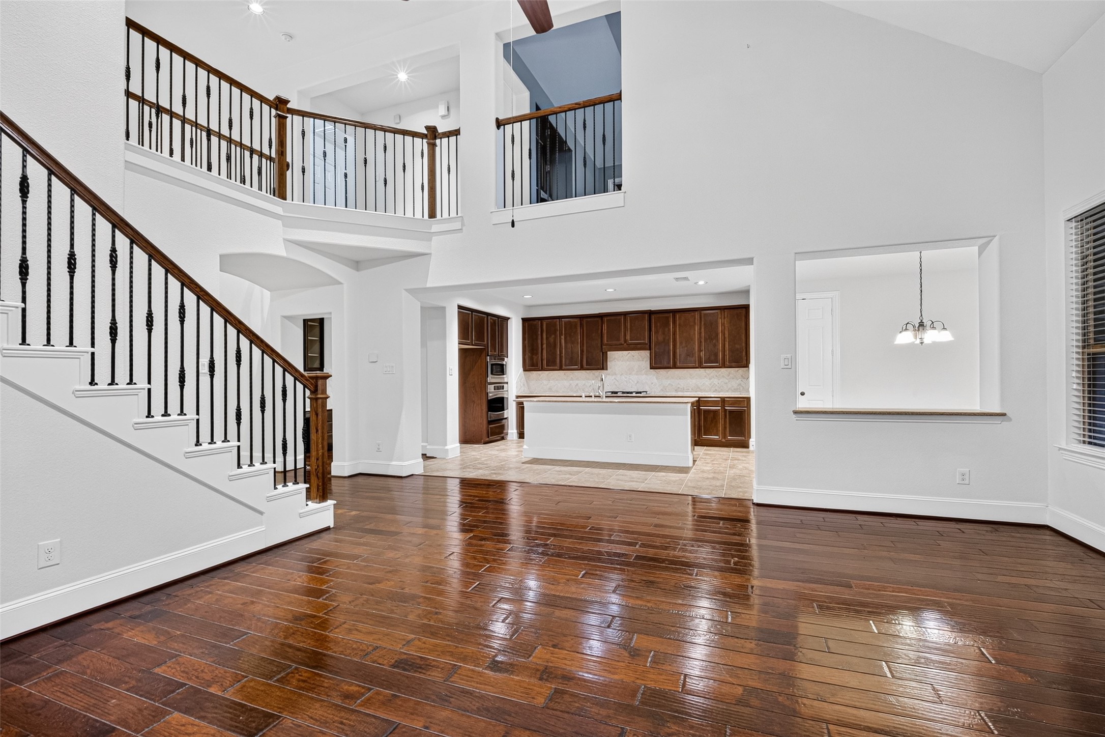 7930 Summer Night Lane Rosenberg, TX 77469 - Photo 12 of 48 Open-concept living area showcasing a dramatic staircase, balcony overlook, and seamless flow to the kitchen.