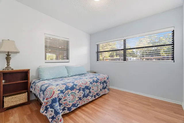 a bedroom with a bed wooden floor and window
