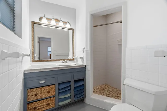 a bathroom with a sink a toilet and shower