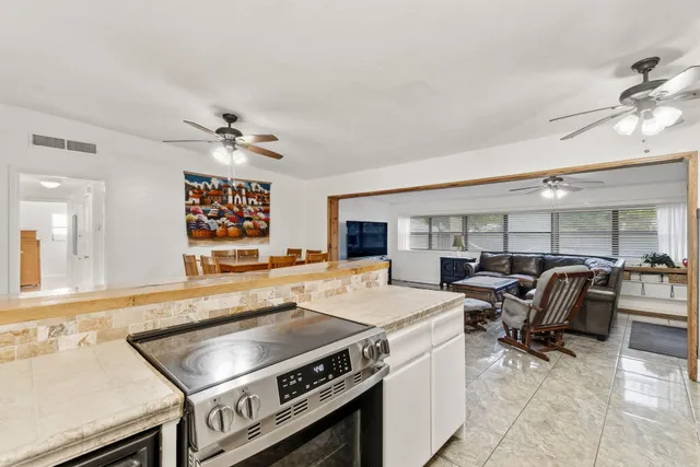 a kitchen with a stove a sink a dining table and chairs with wooden floor