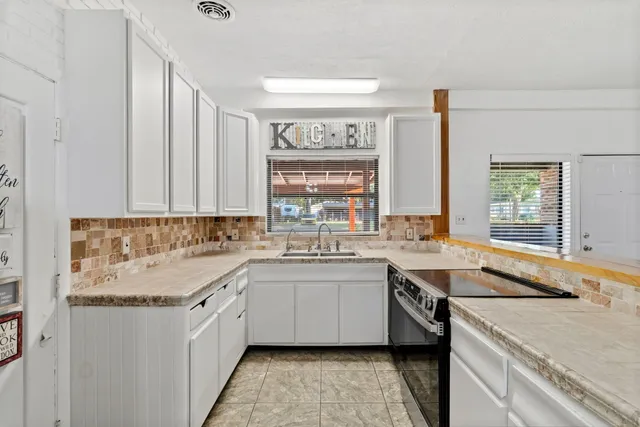 a kitchen with a sink stove and cabinets