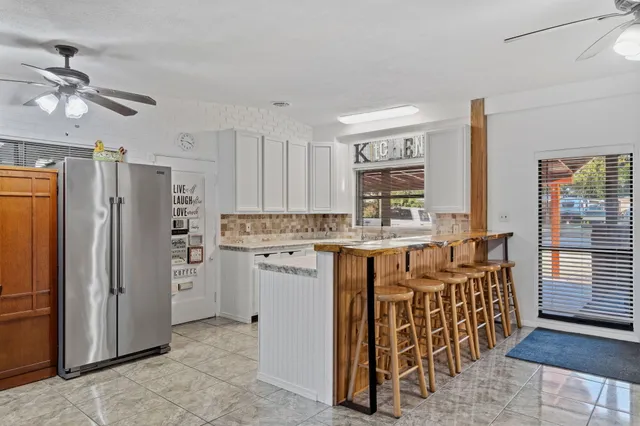 a open kitchen with a refrigerator and a sink