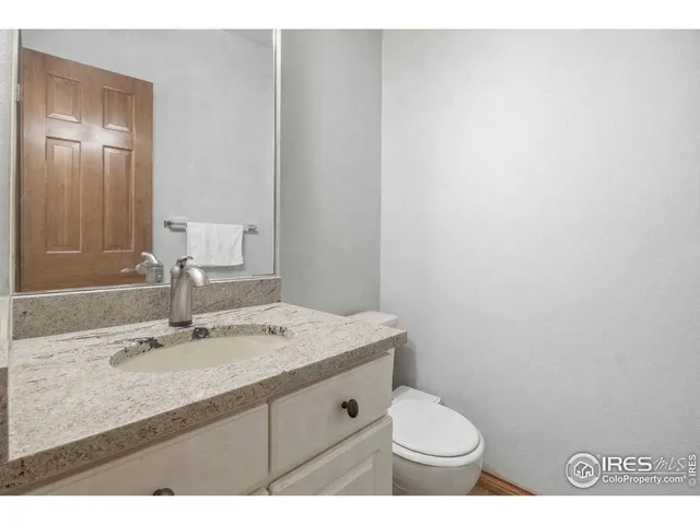 a bathroom with a granite countertop sink toilet and mirror