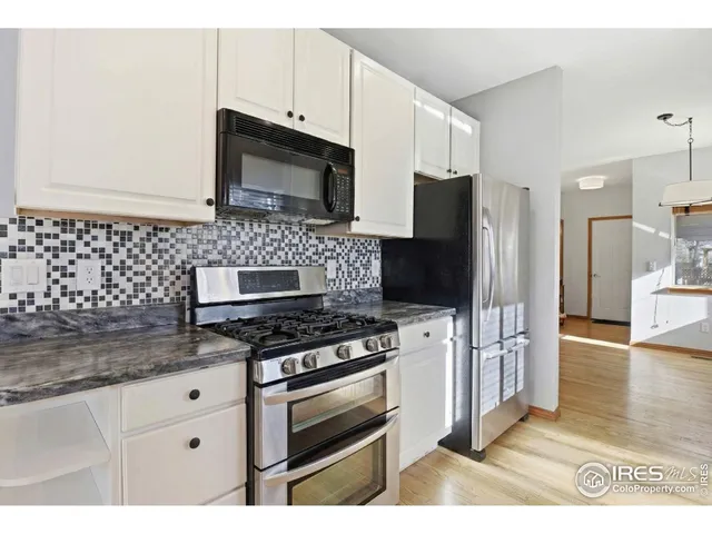 a kitchen with stainless steel appliances a stove a microwave a sink and cabinets
