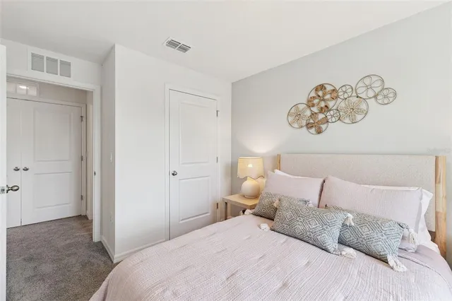 a bedroom with a bed and painting on the wall