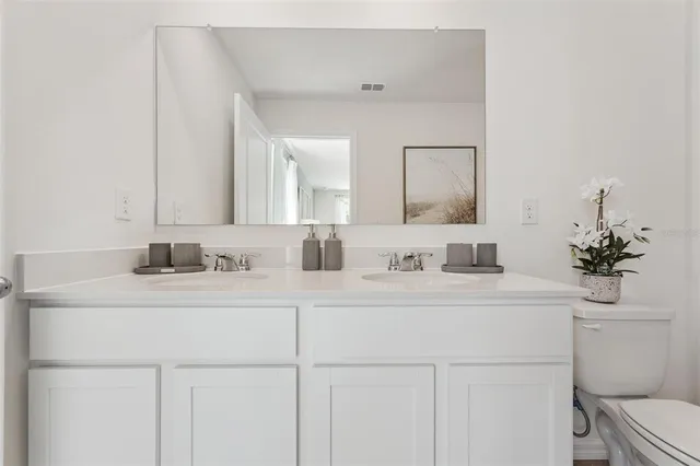 a bathroom with a sink a toilet and a mirror