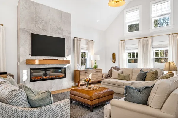 a living room with furniture a fireplace and a flat screen tv