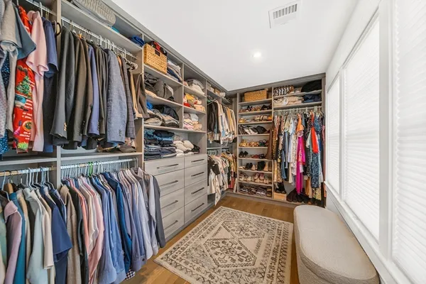 a view of walk in closet with clothes