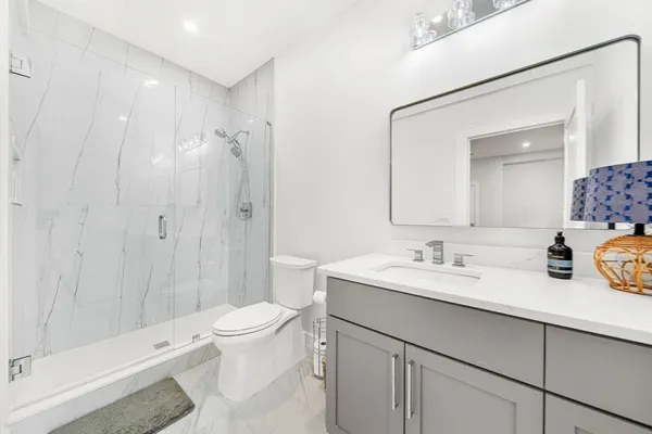 a bathroom with a sink a toilet and shower