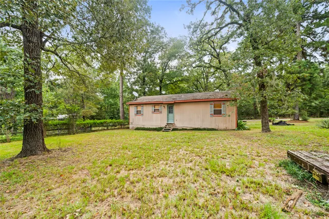 a house is sitting in middle of forest