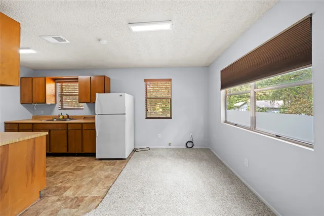 a view of kitchen with window and refrigerator