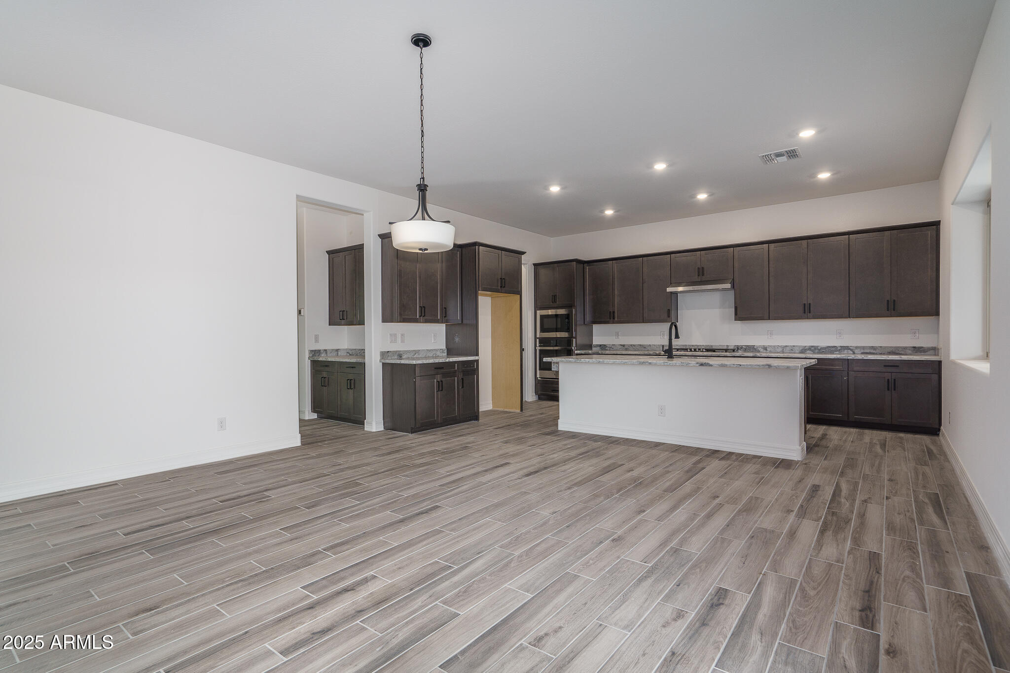 18575 West Sapium Way Goodyear, AZ 85338 - Photo 10 of 51 a view of kitchen with granite countertop stainless steel appliances and wooden floor