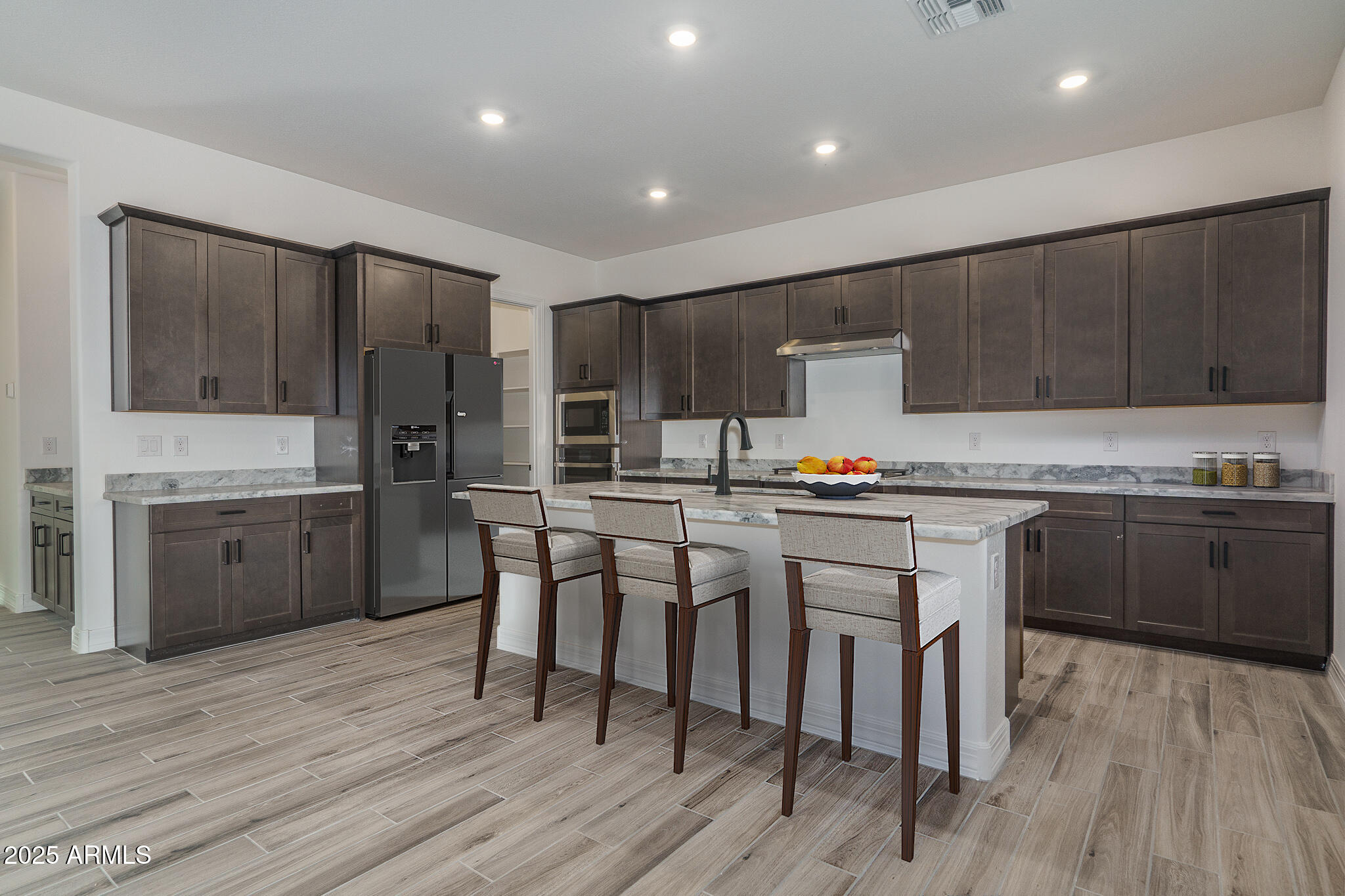 18575 West Sapium Way Goodyear, AZ 85338 - Photo 12 of 51 a kitchen with a sink cabinets and wooden floor