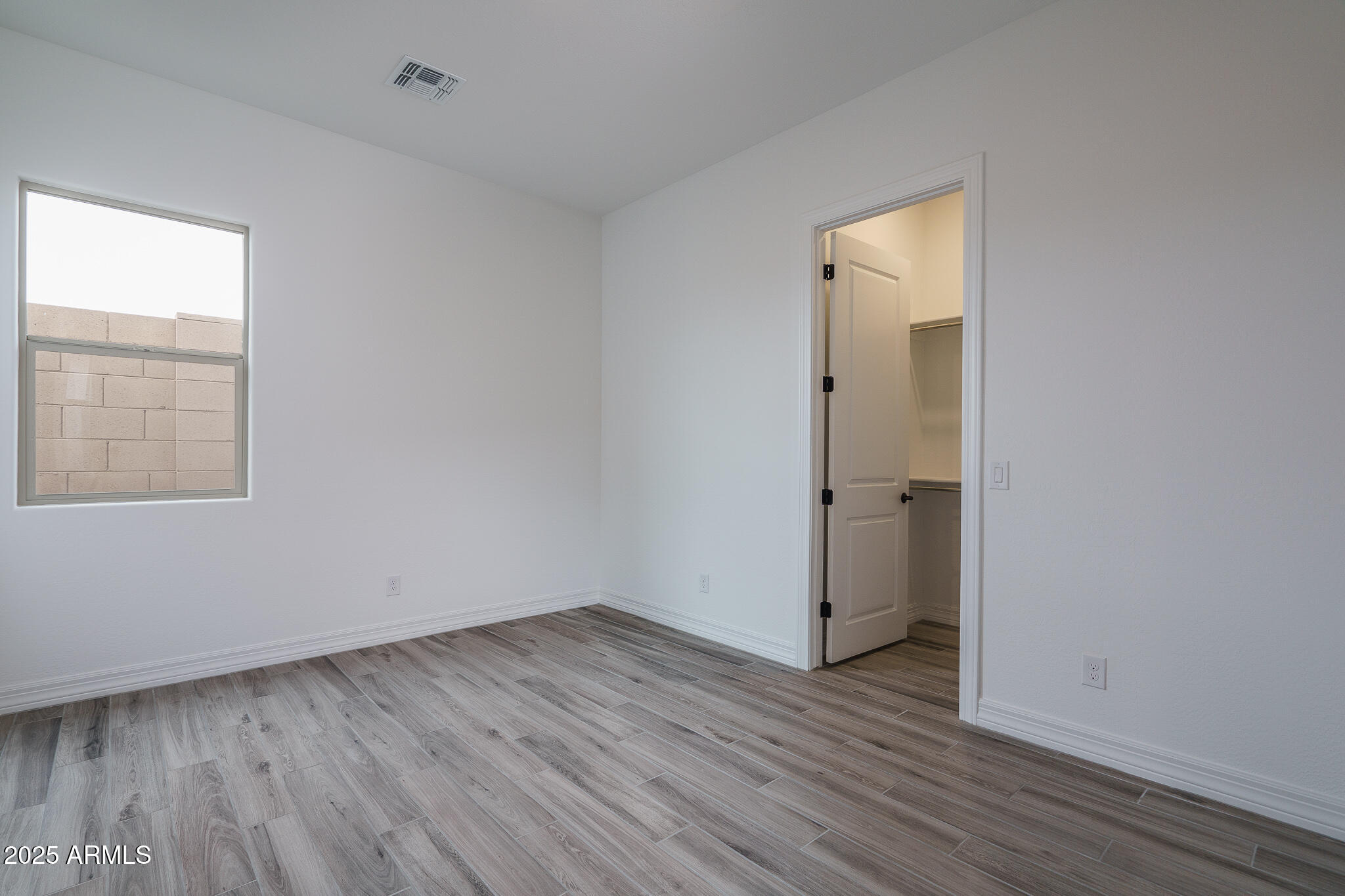 18575 West Sapium Way Goodyear, AZ 85338 - Photo 21 of 51 an empty room with wooden floor and windows
