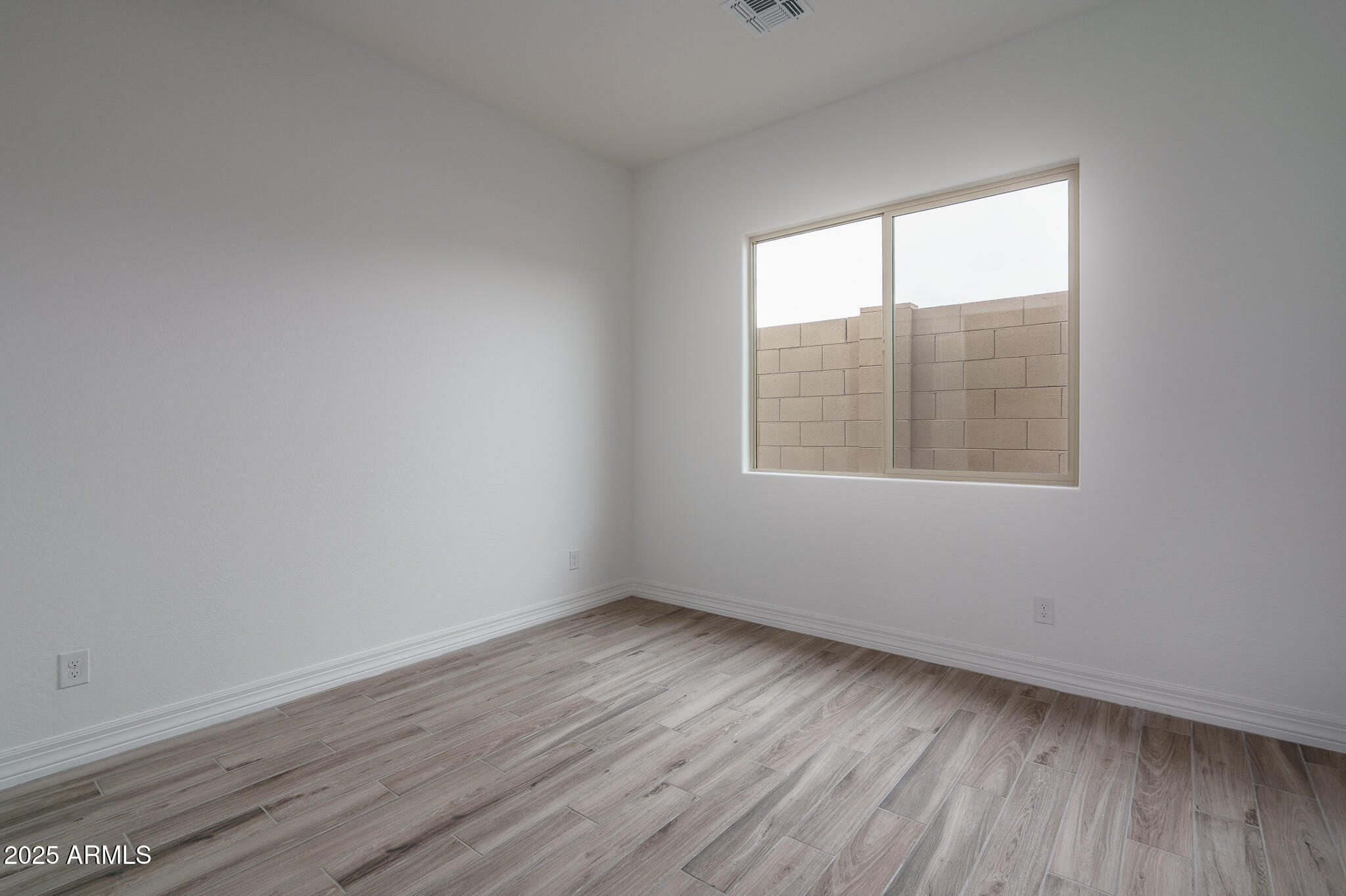 18575 West Sapium Way Goodyear, AZ 85338 - Photo 23 of 51 an empty room with wooden floor and windows