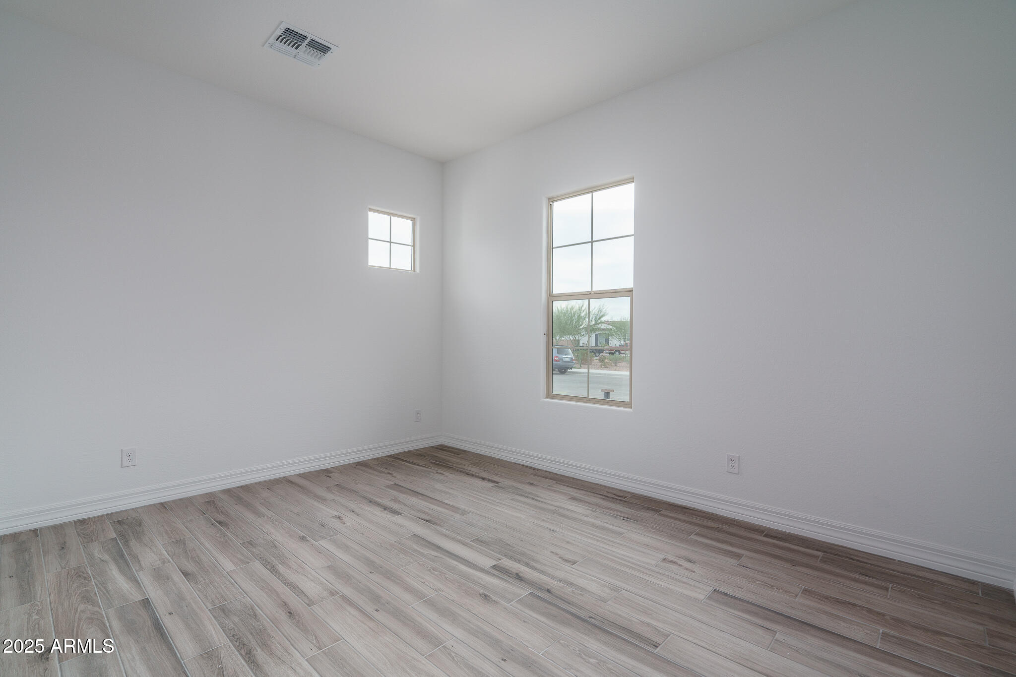 18575 West Sapium Way Goodyear, AZ 85338 - Photo 26 of 51 an empty room with wooden floor and windows