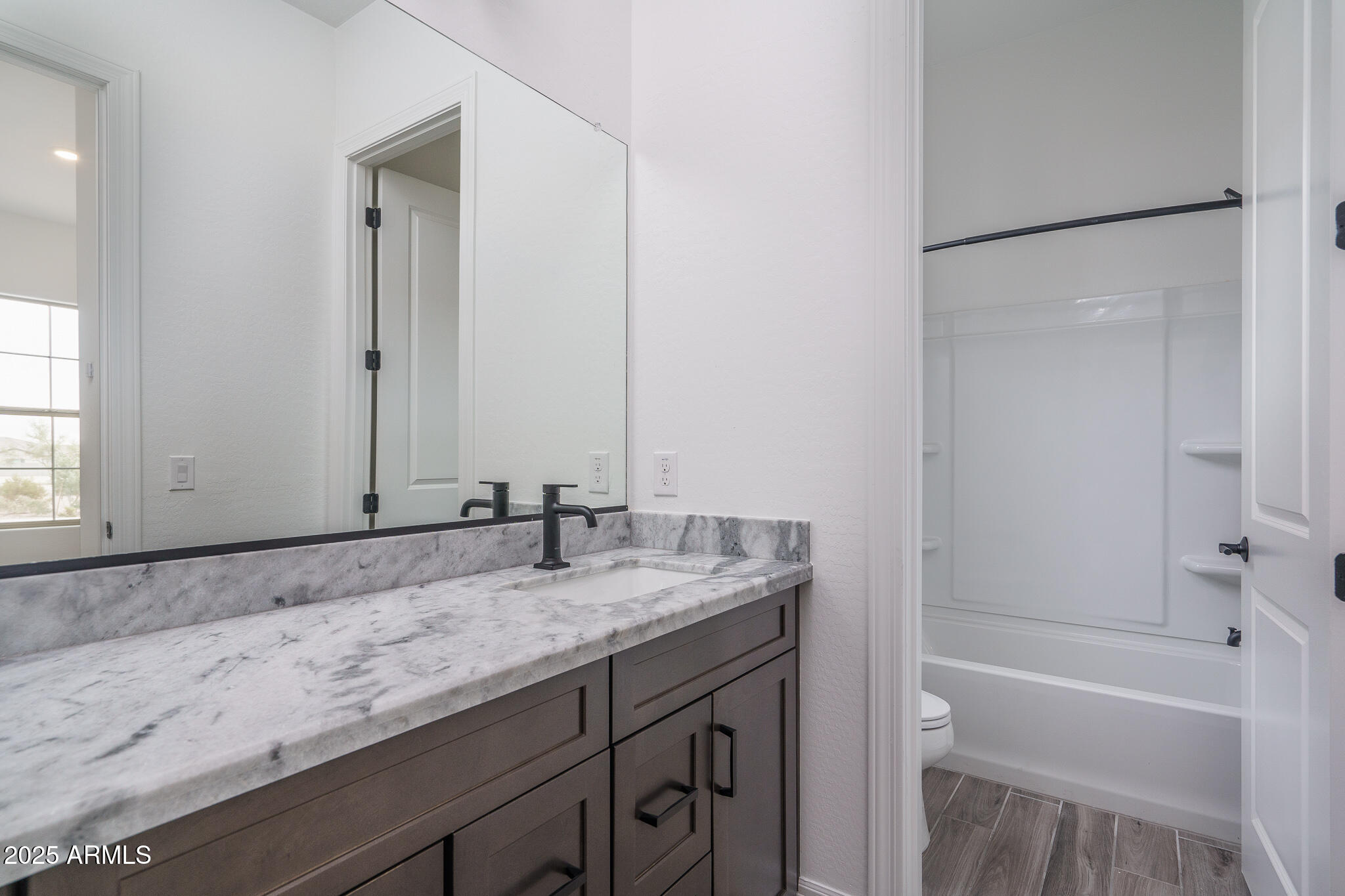 18575 West Sapium Way Goodyear, AZ 85338 - Photo 28 of 51 a bathroom with a granite countertop sink and a mirror