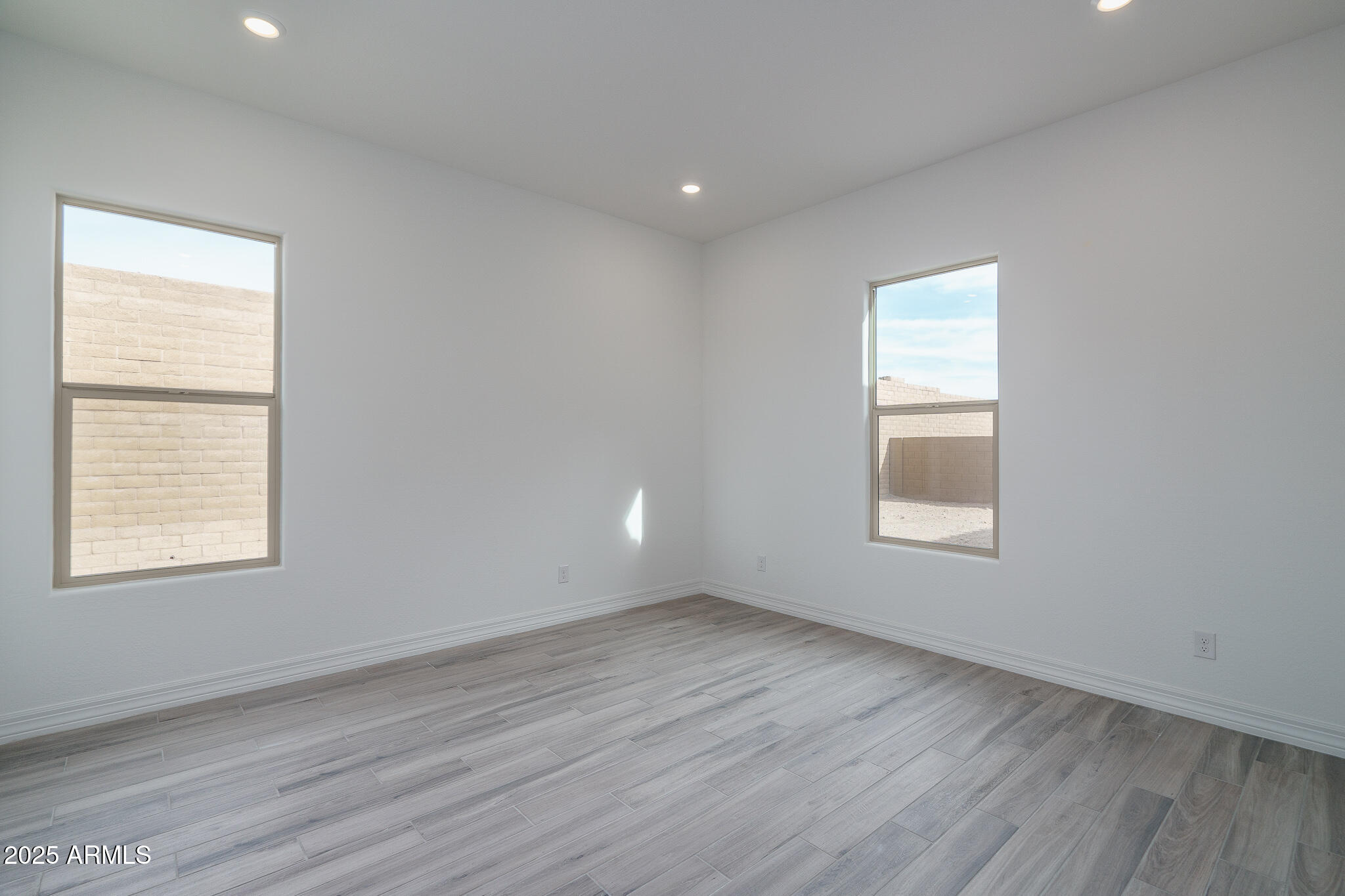 18575 West Sapium Way Goodyear, AZ 85338 - Photo 36 of 51 an empty room with wooden floor and windows