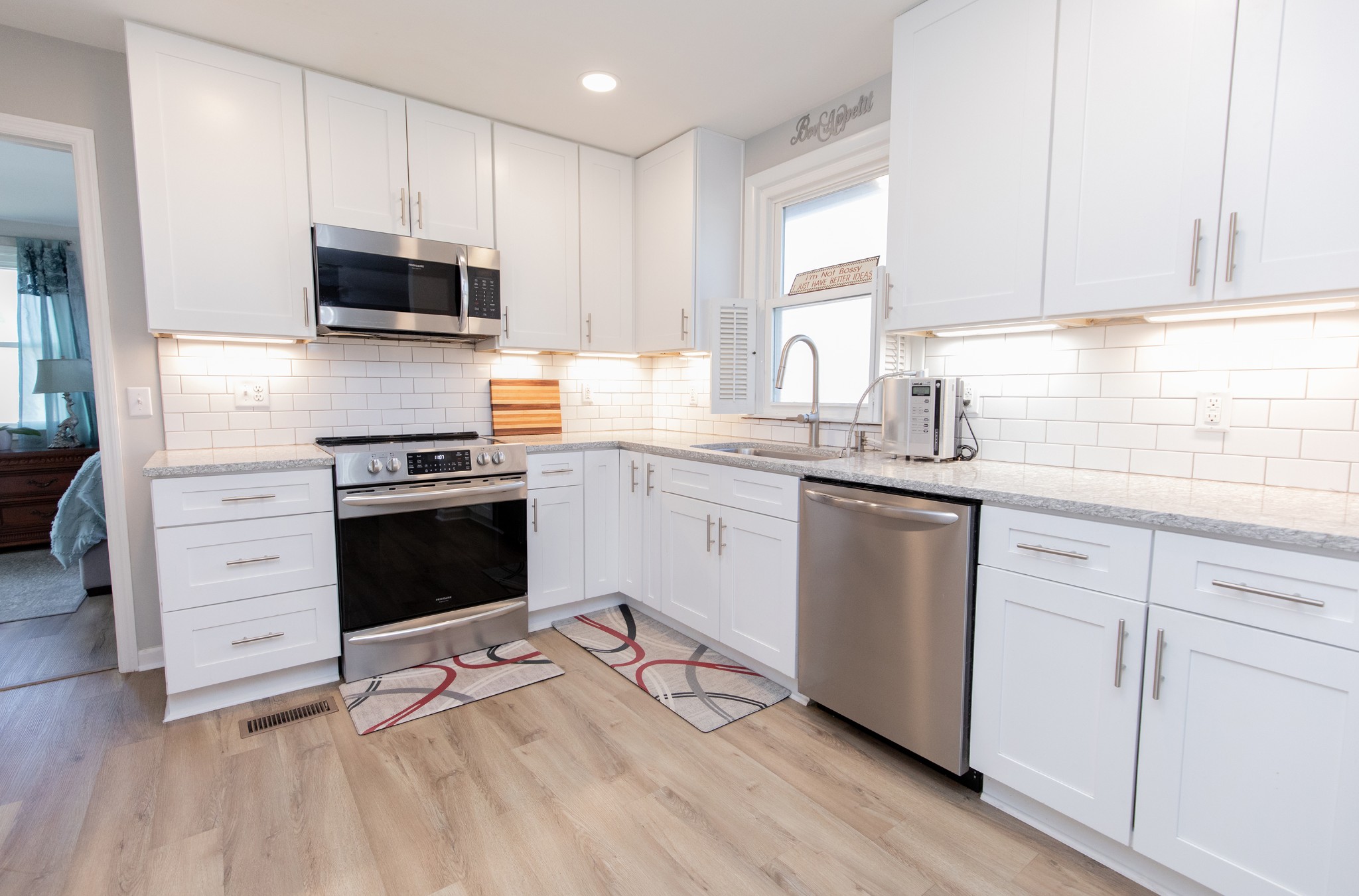 a kitchen with stainless steel appliances a stove microwave and sink