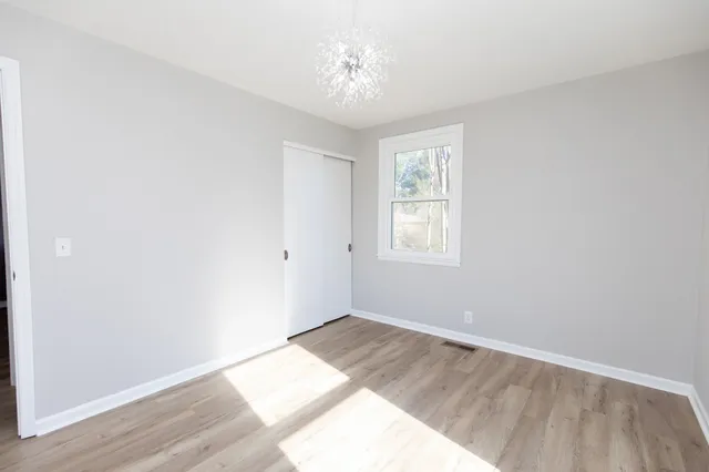 a view of a hallway with white walls and a window