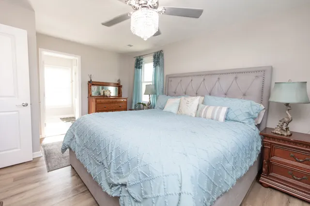 a bedroom with a large bed and a chandelier