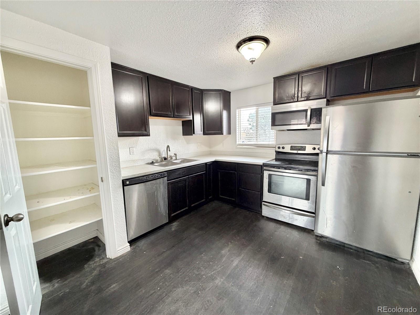 1080 South Eliot Street, Unit 202 Denver, CO 80219 - Photo 2 of 8 a kitchen with a sink stainless steel appliances and cabinets