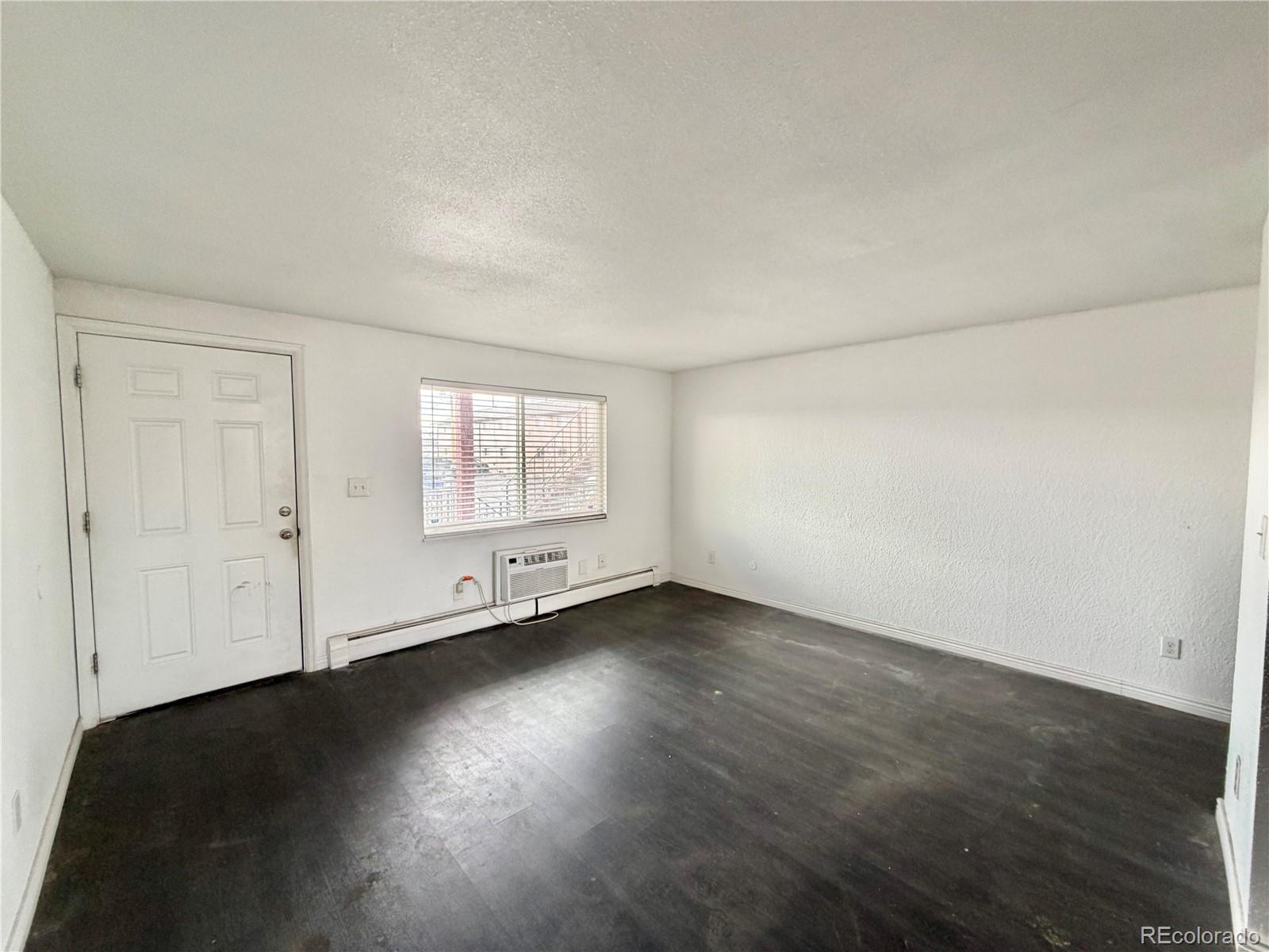 1080 South Eliot Street, Unit 202 Denver, CO 80219 - Photo 4 of 8 an empty room with wooden floor and windows