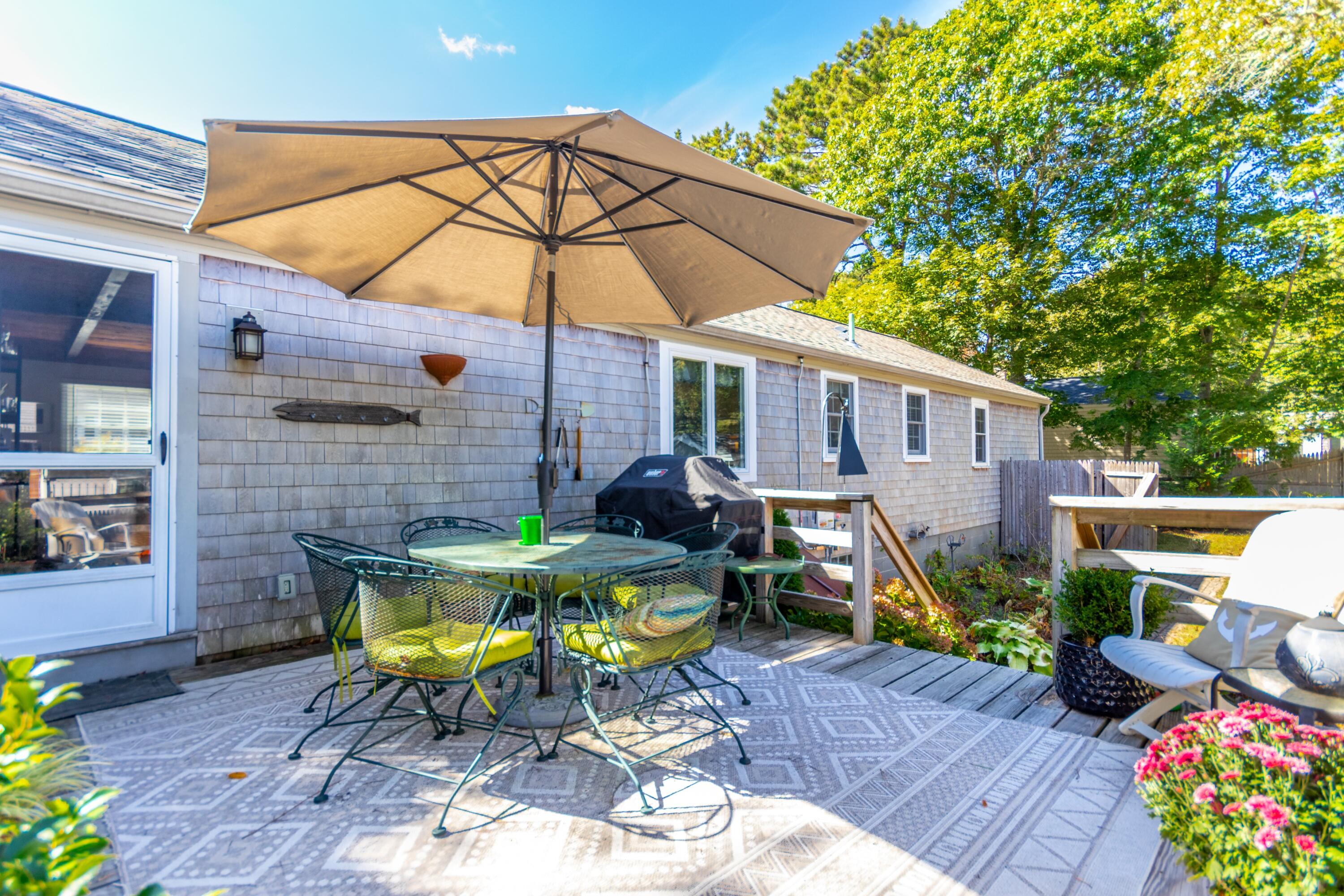 42 Agnes Road South Dennis, MA 02660 - Photo 26 of 36 a view of a patio with table and chairs under an umbrella