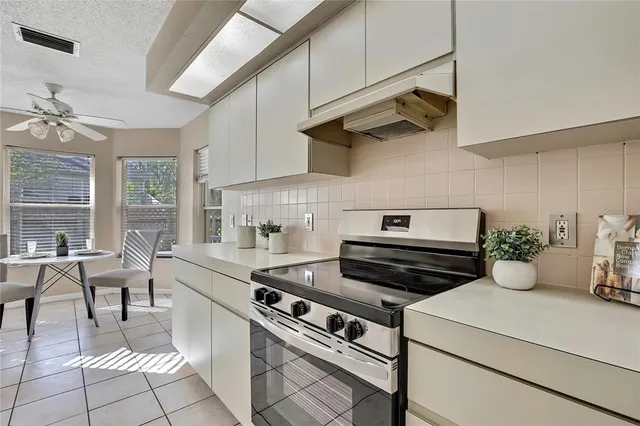 a kitchen with stainless steel appliances granite countertop a sink a stove a refrigerator and cabinets