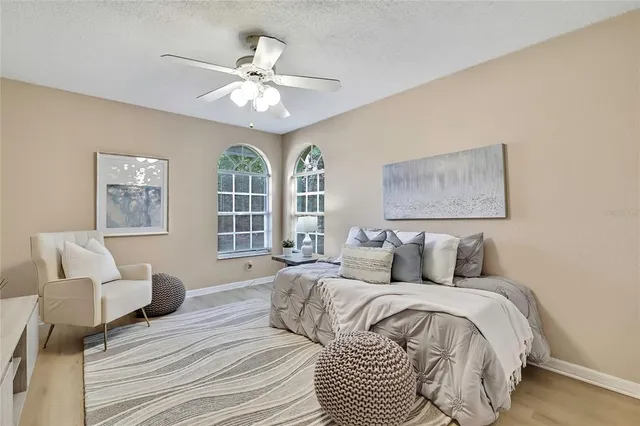 a spacious bedroom with a bed and a chandelier