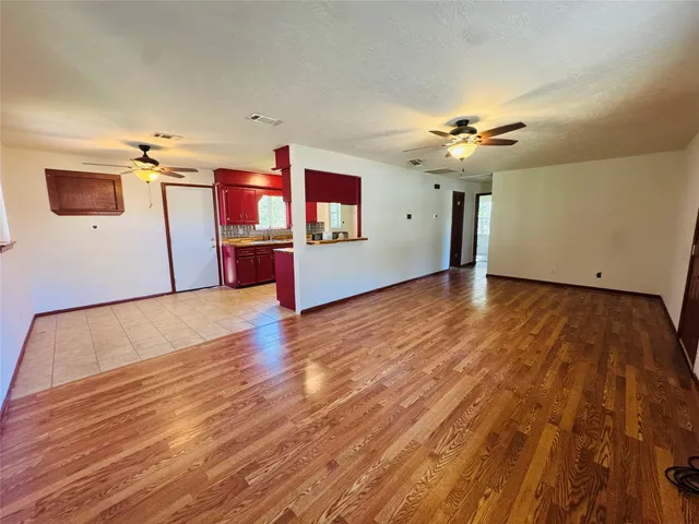 a view of a room with wooden floor and ceiling fan