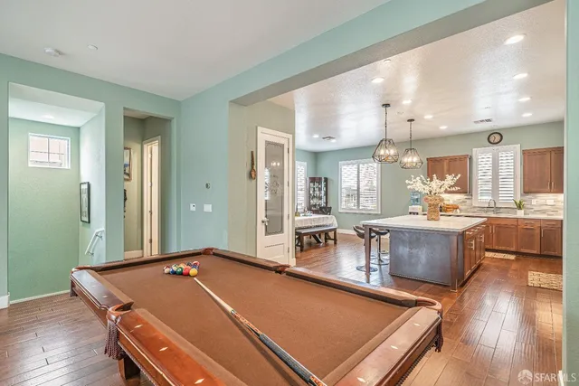a room with pool table and windows
