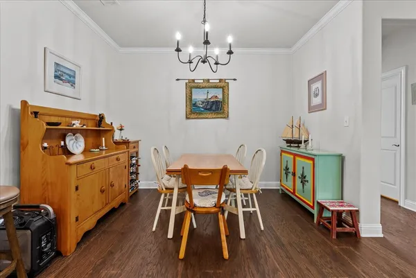 a kitchen with stainless steel appliances kitchen island granite countertop a table chairs refrigerator and microwave