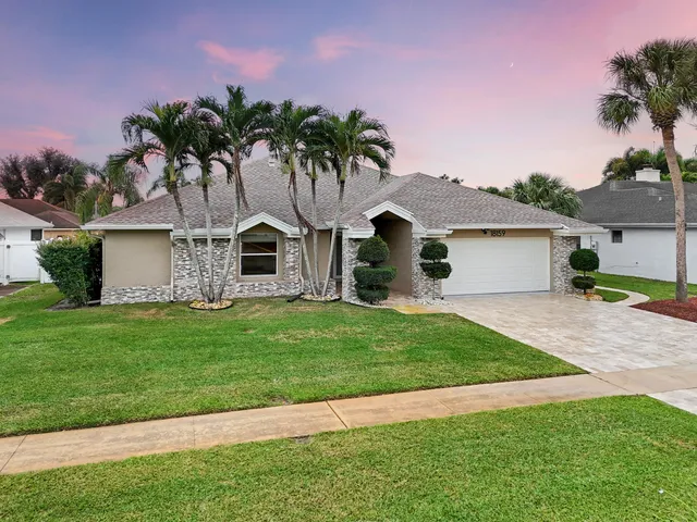 a front view of a house with a garden and plants