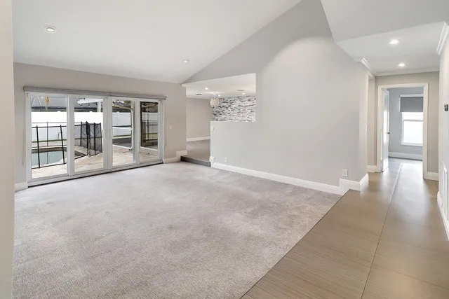 en empty room with windows and chandelier