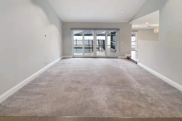 an empty room with a cabinet and mirrors