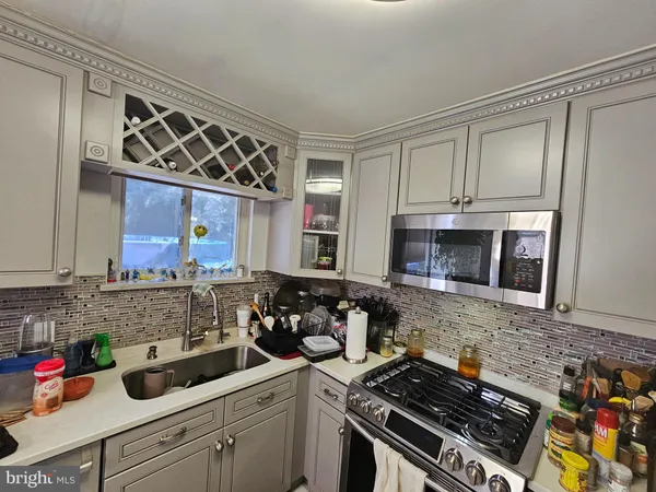 a kitchen with stainless steel appliances a stove a sink and a microwave