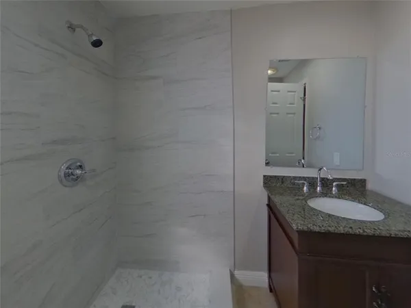 a bathroom with a granite countertop sink and mirror