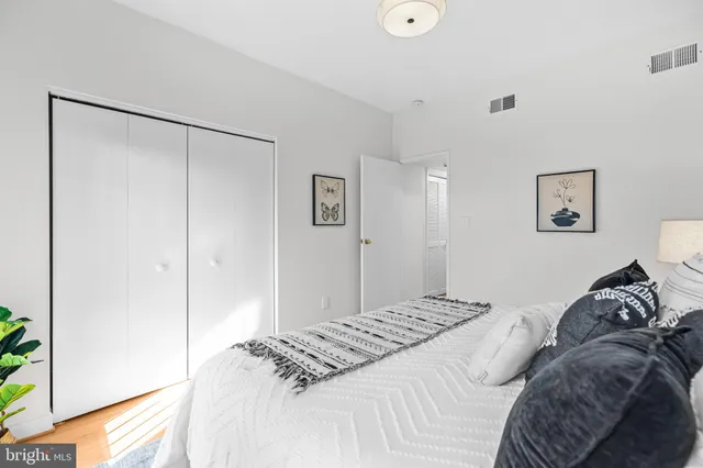 a bedroom with a bed and a painting on the wall