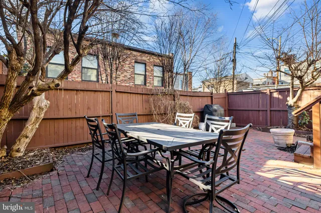 a view of a patio with table and chairs with wooden floor and fence