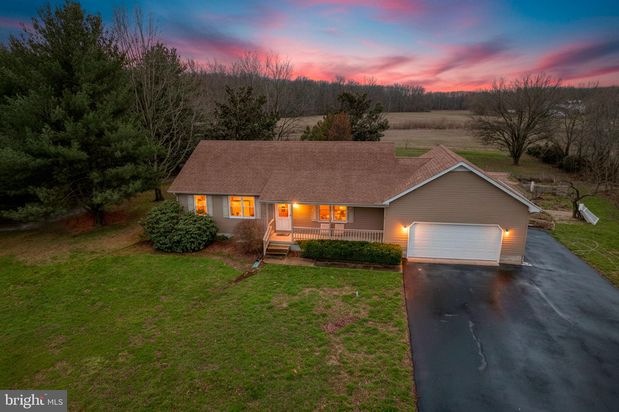 a view of a big house with a big yard plants and large trees