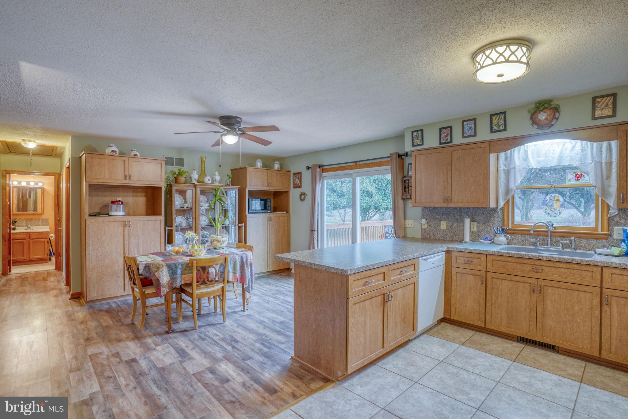 1916 Hartly Road Hartly, DE 19953 - Photo 17 of 44 a open kitchen with stainless steel appliances granite countertop a stove top oven a sink dishwasher a dining table and chairs with wooden floor