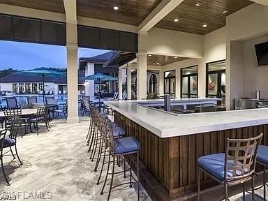 2134 Antigua Lane Naples, FL 34120 - Photo 20 of 26 a kitchen with stainless steel appliances granite countertop a table chairs and a refrigerator