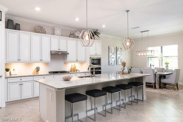 2134 Antigua Lane Naples, FL 34120 - Photo 4 of 26 a kitchen with stainless steel appliances kitchen island granite countertop a sink a stove a dining table and chairs