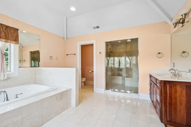 a spacious bathroom with a tub shower and sink