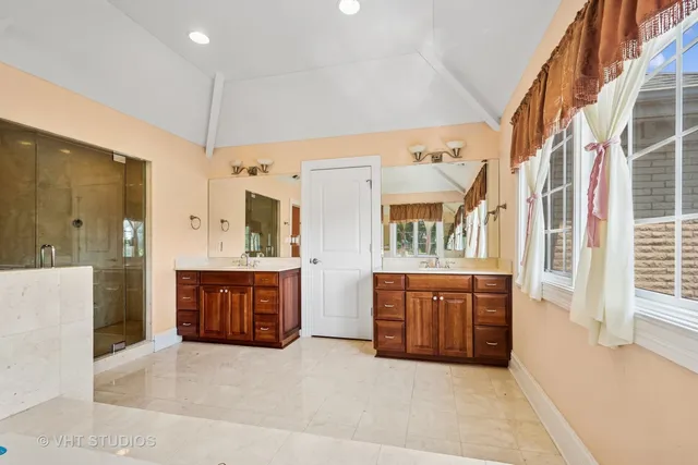 a large spacious bathroom with a granite countertop double vanity sink mirror and a bathtub