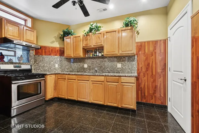 a kitchen with stainless steel appliances granite countertop a sink a stove a refrigerator and cabinets