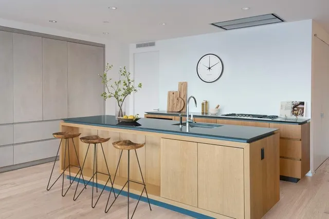 a kitchen with stainless steel appliances granite countertop a table chairs and wooden floors