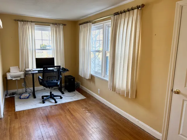 a view of a workspace with furniture and a window