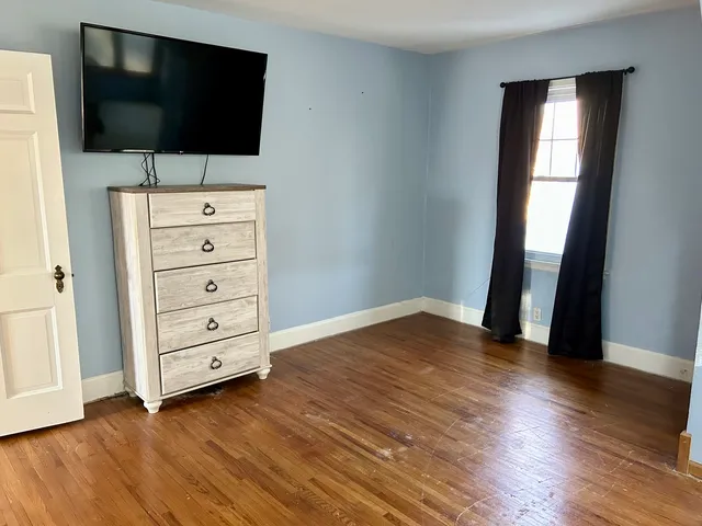 a view of room with wooden floor and flat screen tv